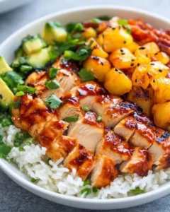 Assiette de poulet BBQ hawaïen caramélisé avec riz blanc, ananas grillés et coriandre fraîche