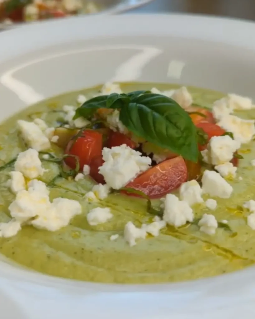 Verrine de gaspacho vert concombre-avocat, garnie de pignons de pin et saupoudrée de paprika.